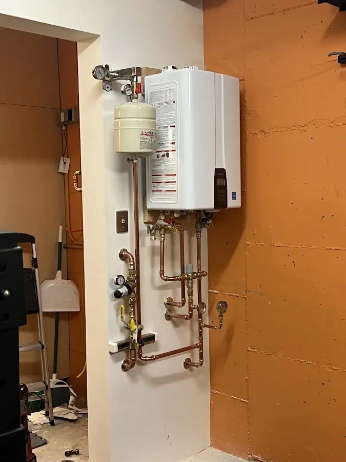 Plumbing technician inspecting water heater connections in Kahaluu